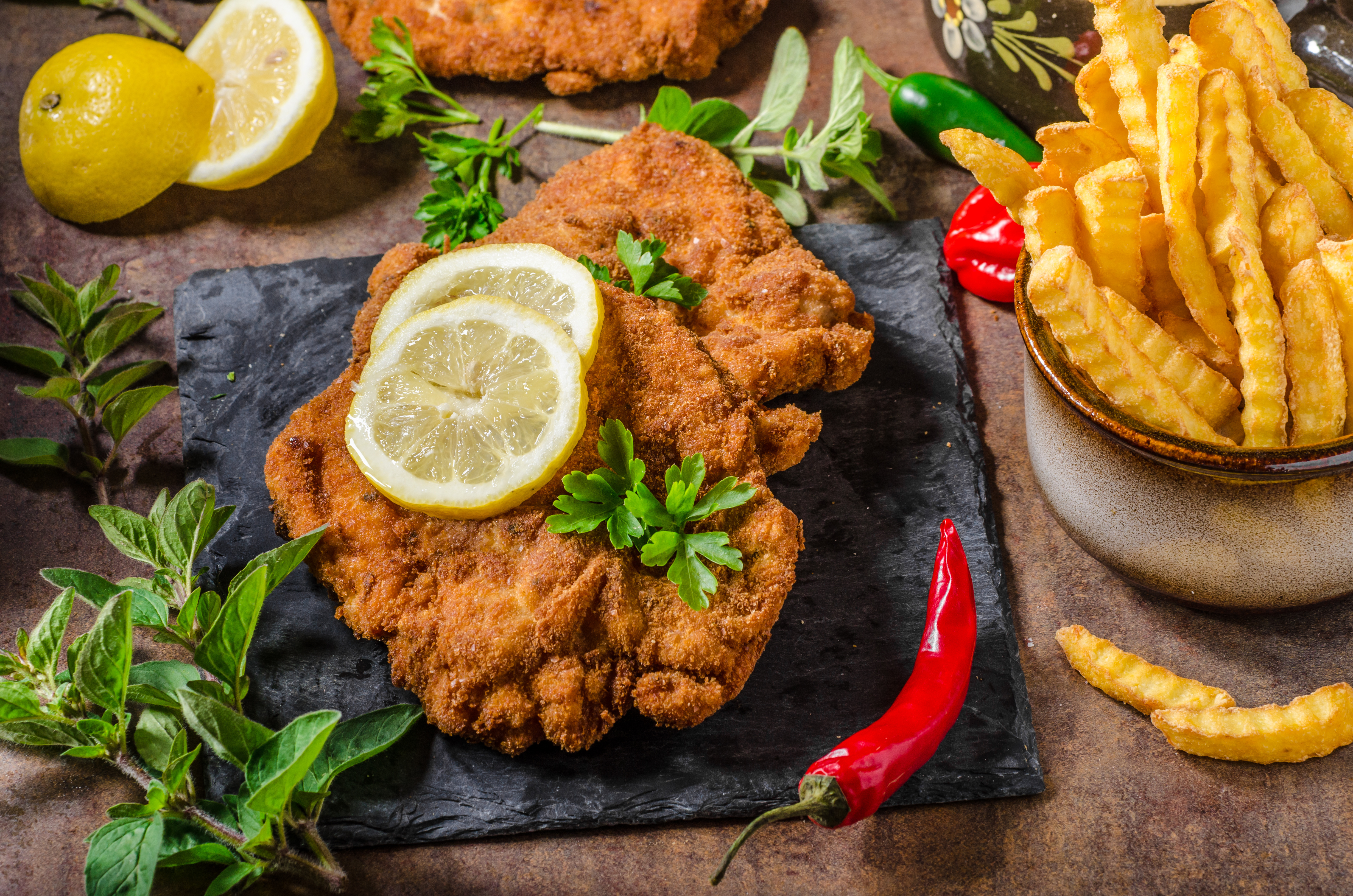 AdobeStock_114736008_Schnitzel.jpeg Schnitzel with fries, salad and herbs
